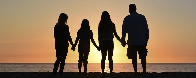 Family silhouette against a sunset